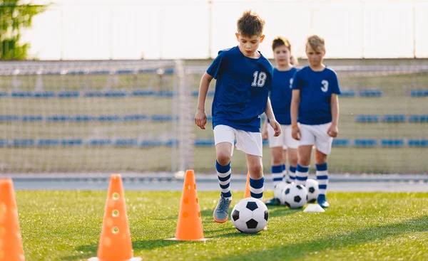 Junior soccer players developing soccer dribbling skills