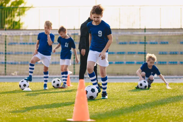 足球体育课。儿童在学校赛场上训练足球 — 图库照片