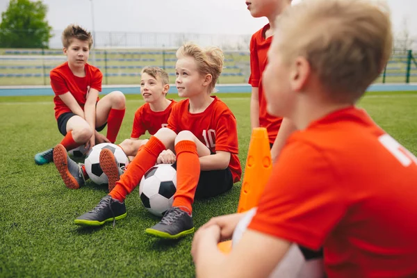 Szczęśliwe dzieci w szkolnej drużynie sportowej. Chłopcy zbierają i bawią się na boisku sportowym — Zdjęcie stockowe