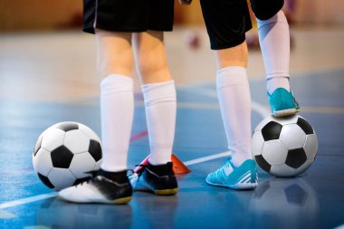 Futsal futbol antrenmanı. Eğitimli iki genç futsal oyuncusu. Futbolcuların bacaklarına yakın çekim