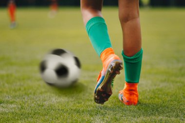 Tekli futbol oyuncusu topun yanında vurmaya hazır bekliyor. Üst düzey profesyonel futbolcu ve klasik futbol topu bacakları.
