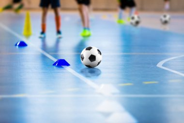 Futsal futbol antrenman sahası. Eğitimli genç sporcular. Futsal topa yakın çekim. Ev İçi Eğitiminde Futsal Junior Player. Okul içinde Futbol Kış Sınıfı Futsal Court