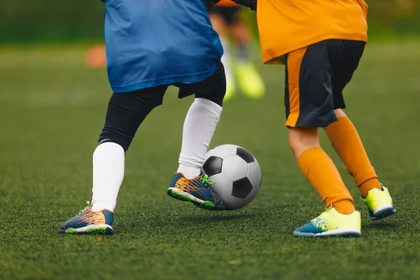 Primer plano de Boys Kicking Soccer Ball. Correr jugadores de fútbol. Futbolistas junior en duelo —  Fotos de Stock