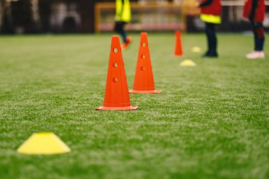 Grass Pitch 'te Spor Eğitimi Ekipmanı. Futbol konileri ve işaretleyicileri. Arka planda Antrenman Birimi 'nde Genç Futbolcular