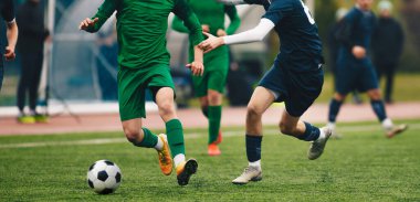 Futbolcular turnuva maçında hareket halindeler. Futbol oyuncuları maç sırasında stadyumda top ve top için yarışıyorlar. Yetişkin futbol müsabakası