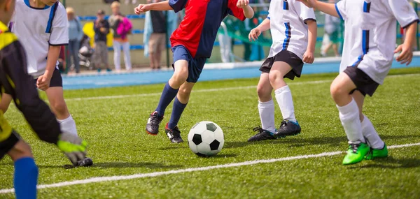 ウェット グラス フィールドでサッカーボールを蹴っている若い選手 デュエルのユースサッカー選手 子供たちは学校のフィールドでスポーツゲームをキック キッズレベルサッカートーナメント — ストック写真