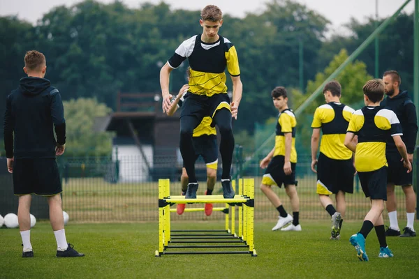 Ασκήσεις Προπόνησης Ποδοσφαίρου Εμπόδια Ευκινησία Ποδοσφαιριστές Πηδούν Ψηλά Πάνω Από — Φωτογραφία Αρχείου