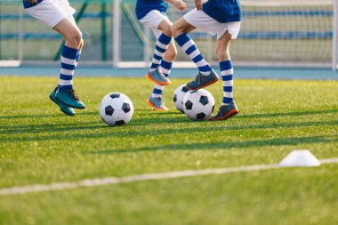 Okul antrenmanında futbol topları olan çocuklar.