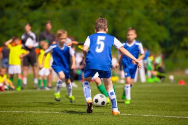 Çocuklar için futbol maçı var. Antrenman ve futbol okulu turnuvası. Futbol oynayan çocuklar grubu.