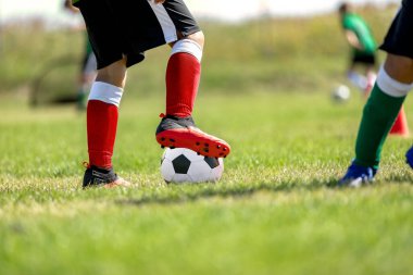 Çocuk futbol antrenmanı taze çimen sahası üzerinde. Çocuklar için futbol kampı. Çocuklar tarlada top sürme pratiği yapıyor. Oyuncu top sürme yeteneğini geliştirir. Spor giyim antrenmanında top oynayan çocuk.