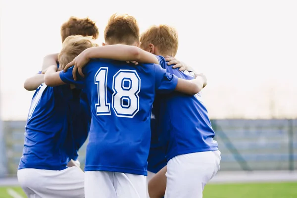 Children Play Sports in a Team. Boys Huddling Before the Game. Kids Sports Team United Ready to Play Match. School Age Boys in Blue Sports Uniforms