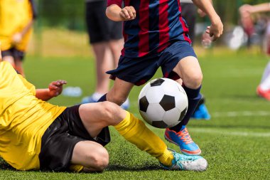 Futbol topu yakalama anı. Futbol maçıyla baş etme becerisi. Bir düelloda iki futbolcu. Okul çağında koşan çocuklar. Çocuklar çimlerde futbol topunu tekmeliyor.
