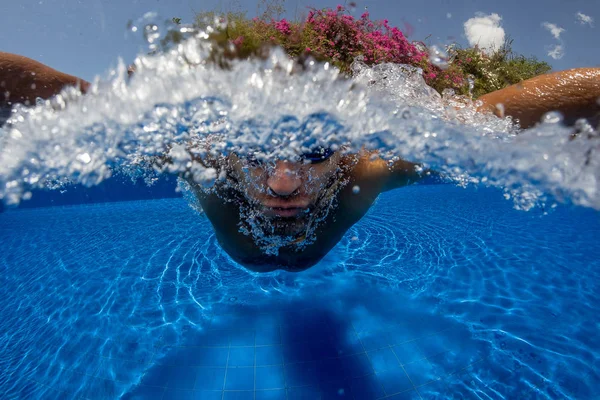 Face of swimming man in pool blue water close up.