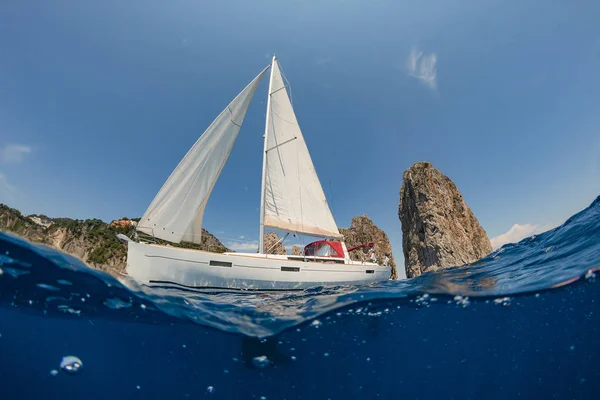 Uno Yacht Vela Galleggiante Sul Mare Sullo Sfondo Scogliere Spiaggia — Foto Stock