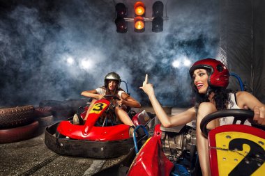 Kız Go-kart Karting hızı ile sürüyor. Saldırgan kadın gösteren parmak