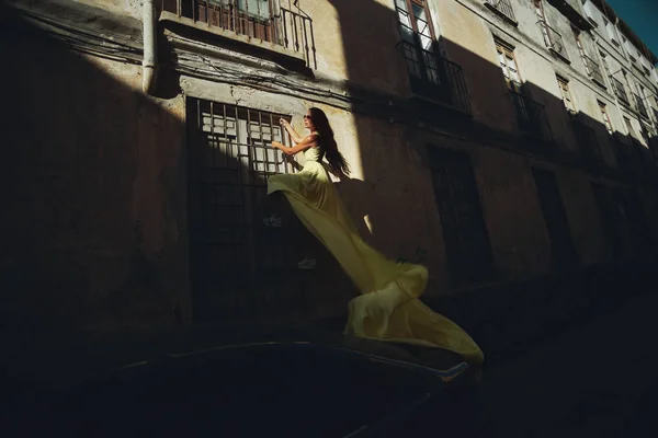 Una Mujer Con Vestido Amarillo Largo Está Escalando Una Ventana —  Fotos de Stock