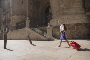 Güzel kadın sokakta yürürken bavul taşıma 