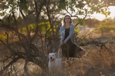 Beyaz köpekle gezen bir kadın.