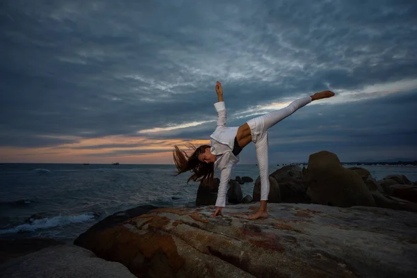 美丽的运动女人练习瑜伽阿萨纳在日落时在海滩上 — 图库照片