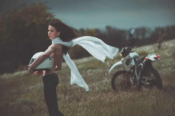 Chica motociclista junto a una motocicleta —  Fotos de Stock