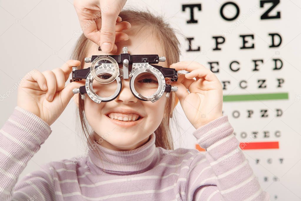 Optician. Young girl undergoing eye test 