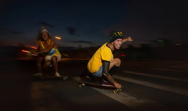 Skateboarders ride skateboards at night — Stock Photo, Image