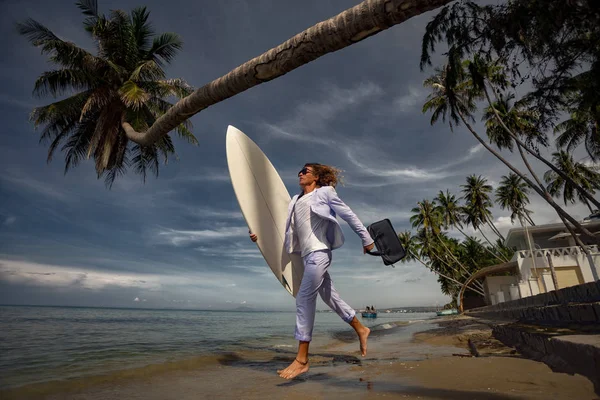 ビーチでサーフボードを持つファッションビジネスマン — ストック写真