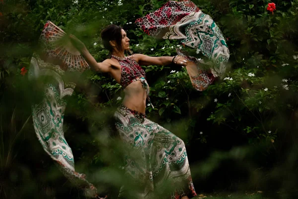 Žena tančí s fanoušky na přírodním tropickém pozadí — Stock fotografie