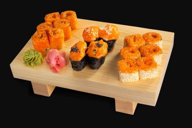 Büyük fırında pişirilmiş karışım: Siyah arka planda fırında somon, karides ruloları, ton balığı ve baharatlı somon gukan