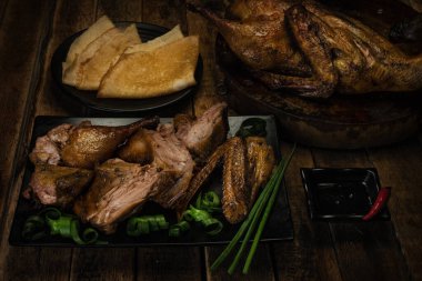 Tabakta yeşil soğanlı Pekin ördeği ve siyah yanmış ahşap arka planda Hoysin soslu buğday buğdaylı krep. Pankart menü tarifi.