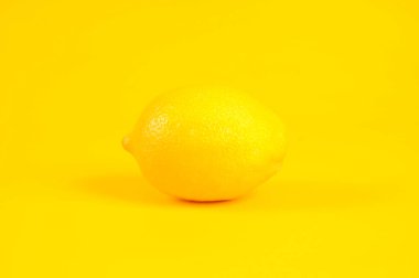 Sarı arka planda izole edilmiş tek limon