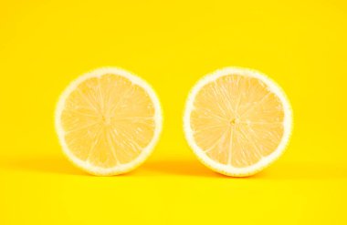 Sarı arka planda dilimlenmiş limon, sarı arkaplanda yarım limon.