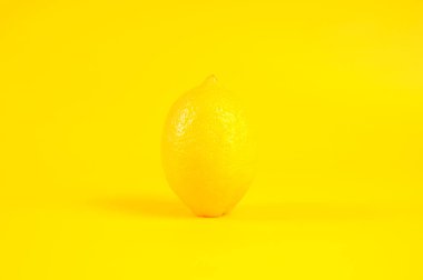 Sarı arka planda izole edilmiş tek limon