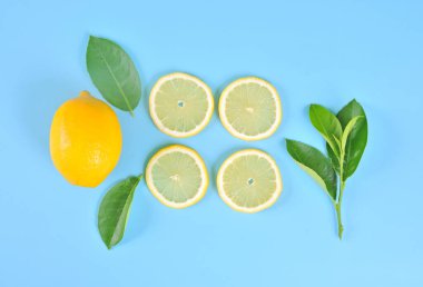 Dilimler ve tüm limon mavi arka planda yaprak, üst manzara