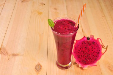 Kırmızı ejderha meyveli içecekler ve yarısı dilimlenmiş bardaklar. Pitahaya meyvesi. Ejderha Meyve Suyu. Yarısı doğranmış ejderha meyvesi.