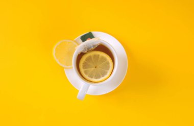 Sarı arka planda dilimlenmiş limonlu limon çayı manzarası