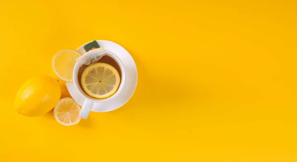 Top view of lemon tea with lemon and sliced on yellow background