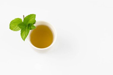 Minik yapraklı ve beyaz arkaplanlı nane çayı