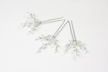 Gümüş ve açık mavi saç tokaları beyaz arkaplanda izole edilmiş.