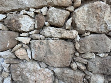 Taş duvar fotoğrafı, dokulu arka plan. Kırsal taştan bir duvara yakın çekim.