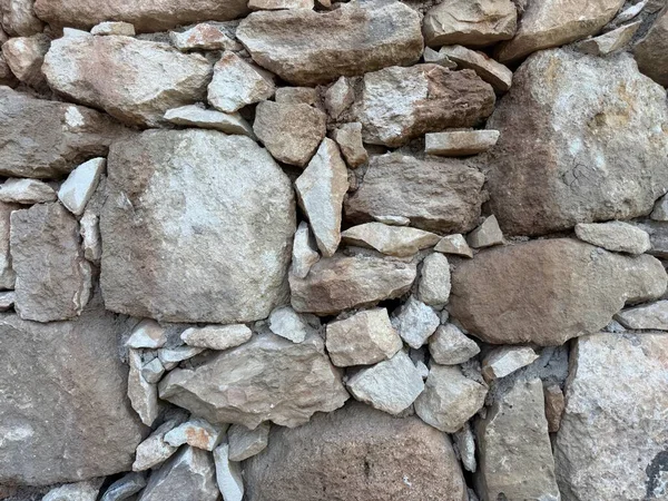 Taş duvar fotoğrafı, dokulu arka plan. Kırsal taştan bir duvara yakın çekim.