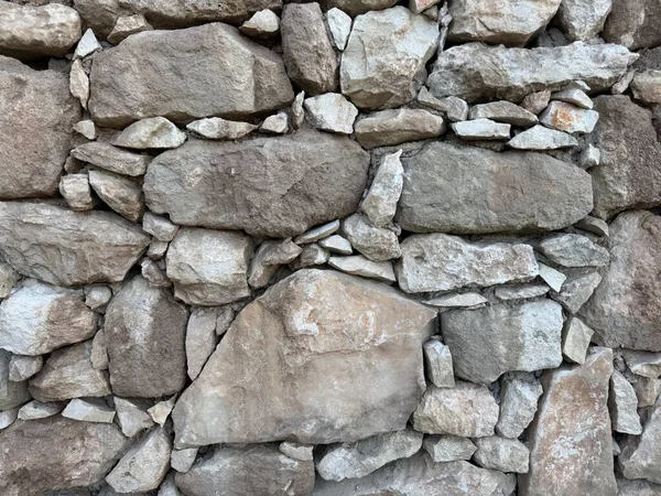 Taş duvar fotoğrafı, dokulu arka plan. Kırsal taştan bir duvara yakın çekim.