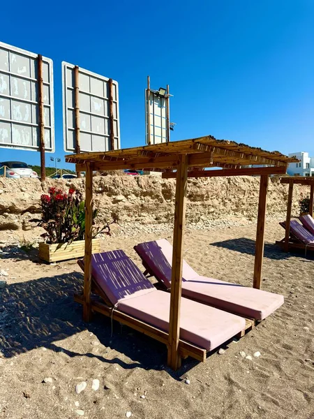 Halk plajı, yaz mevsimi, güzel güneşli hava. Resimli plaj, kumlu kıyıya vuran dalgalar. Deniz dalgaları kayalara çarpıyor. Kıbrıs adası, şemsiyeler, turist botları, Akdeniz.