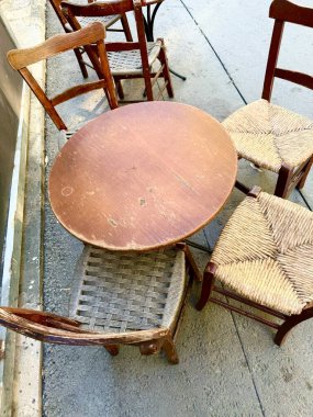 Masası ve sandalyeleri olan açık hava oturma alanı. Güneşli bir yaz günü, restoranın yanında boş bir masa..