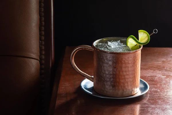 Cold Moscow Mule with Vodka and Ginger Beer in Copper Mug in Dark Luxurious Bar with Copy Space