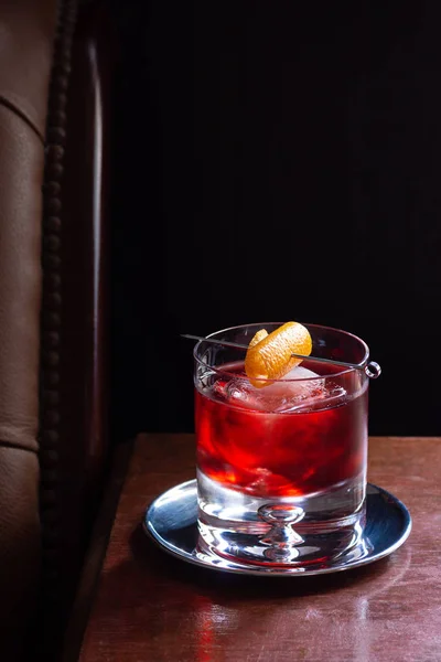 内格罗尼鸡尾酒与金 红威茅斯 和坎帕里 在冰与橙色扭曲在黑暗豪华酒吧与复制空间 — 图库照片