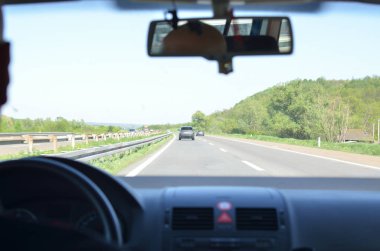 Onun yanında diğer araçlarla onun yönde ve ters yönde bir otoyolda sürüş