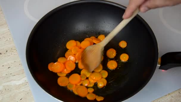 調理プロセス中にニンジンと中華鍋とミキシング スプーン混合野菜のタマネギを追加 — ストック動画