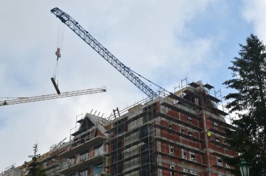 Bulutlu gökyüzü karşı vinçler ile bina inşaat altında