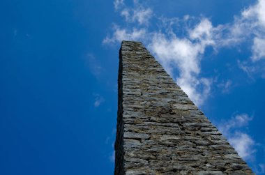 Bir bulut ile mavi gökyüzü karşı taş dikilitaş